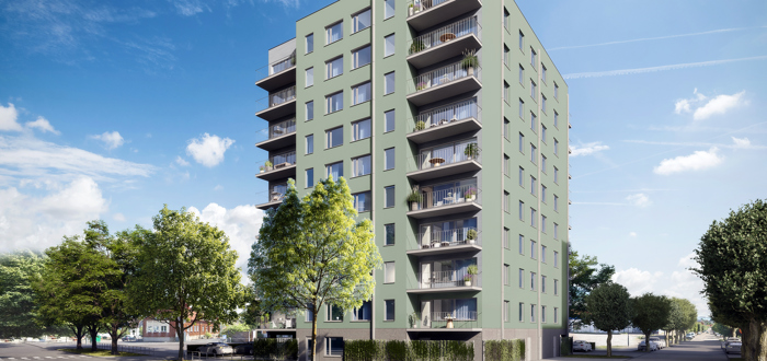 Grön fasad med fönster och balkong från gatuvy